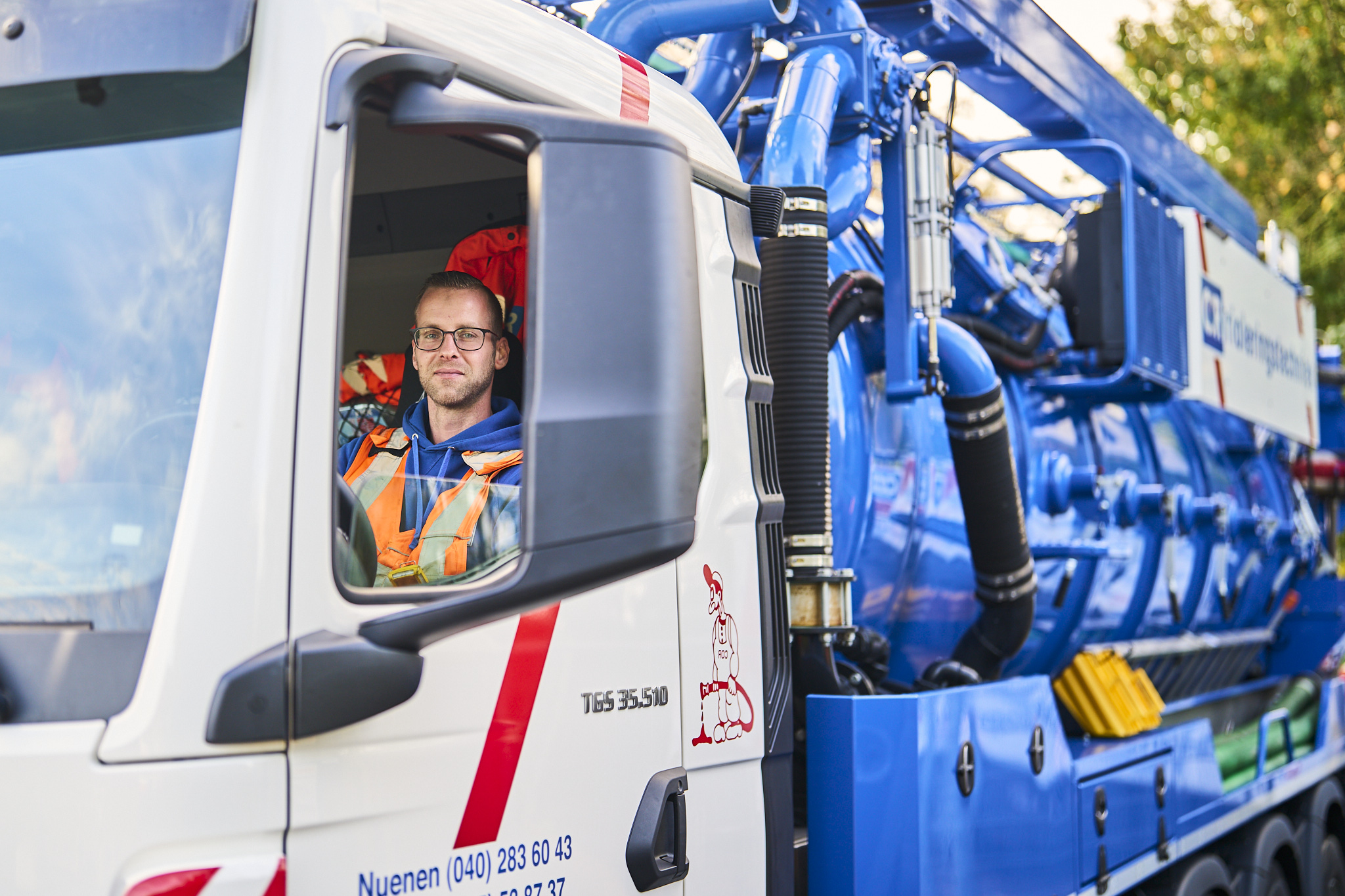 C.O.R.-medewerker in een rioolreinigingswagen
